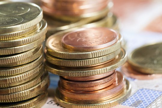 stack of coins of different colors and denominations lying together, closeup with a shallow depth of field